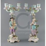 A pair of Meissen bucolic figural candelabra, 19th century, the gentleman figure playing bagpipes
