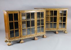 A pair of early 20th century feather banded walnut breakfront dwarf bookcases, with astragal