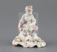 A Derby 'pale family' figure of a seated lady, c.1756, holding flowers in her hands, on a scrollwork