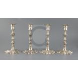 A set of four George II cast silver candlesticks by John Cafe, with waisted knopped stems, on