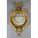 A William IV giltwood and gesso convex wall mirror, with eagle surmount, W.1ft 10in. H.3ft 5in.