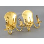 A matched pair of George V silver gilt two branch, two light wall sconces, with gadrooned back plate