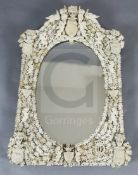 A 19th century Dieppe ivory wall mirror, of arched rectangular form with oval plate, applied with