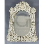 A 19th century Dieppe ivory wall mirror, of arched rectangular form with oval plate, applied with