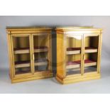 A pair of late Victorian Holland & Sons satinwood dwarf bookcases, with brass anthemion pattern back