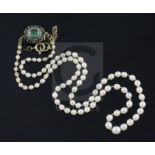 A single strand graduated cultured pearl necklace with emerald cluster set clasp, 50cm.CONDITION: