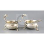 A pair of Victorian silver sauceboats with flying scroll dolphin head handles, London, 1883, on mask