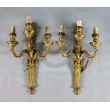 A pair of Adam revival ormolu three branch wall lights, with flaming urn and goat's head backplates,