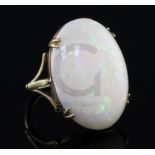 A 9ct gold and oval white opal set dress ring, the stone measuring 27mm by 20mm, with a depth of