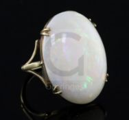 A 9ct gold and oval white opal set dress ring, the stone measuring 27mm by 20mm, with a depth of