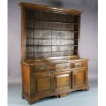 A mid 18th century oak dresser, with boarded three shelf rack, three long drawers and two panelled