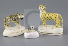 Three Staffordshire porcelain figures of leopards, c.1840-50, the largest on a rocky base, the other