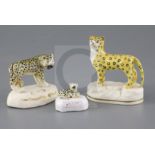 Three Staffordshire porcelain figures of leopards, c.1840-50, the largest on a rocky base, the other