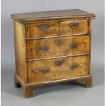 An early 18th century style crossbanded walnut bachelors chest, with burr wood inset folding top,