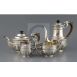 An Edwardian silver four-piece tea and coffee set, rounded body with medallion heads and flying