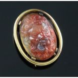 An early 20th century gold mounted oval agate clip brooch, the stone carved with the head of