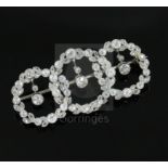 A 1920's white gold and round and rose cut diamond set interlocking triple circle openwork drop