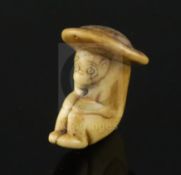 An 18th century Japanese stag horn netsuke of a monkey wearing a broad rimmed hat, depth 4cm