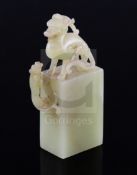 A Chinese greenish-yellow jade seal, 19th/20th century, carved within openwork with a lion-dog and