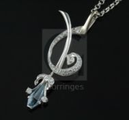 A stylish modern platinum, shaped cut aquamarine and diamond set spray pendant, on a 9ct white