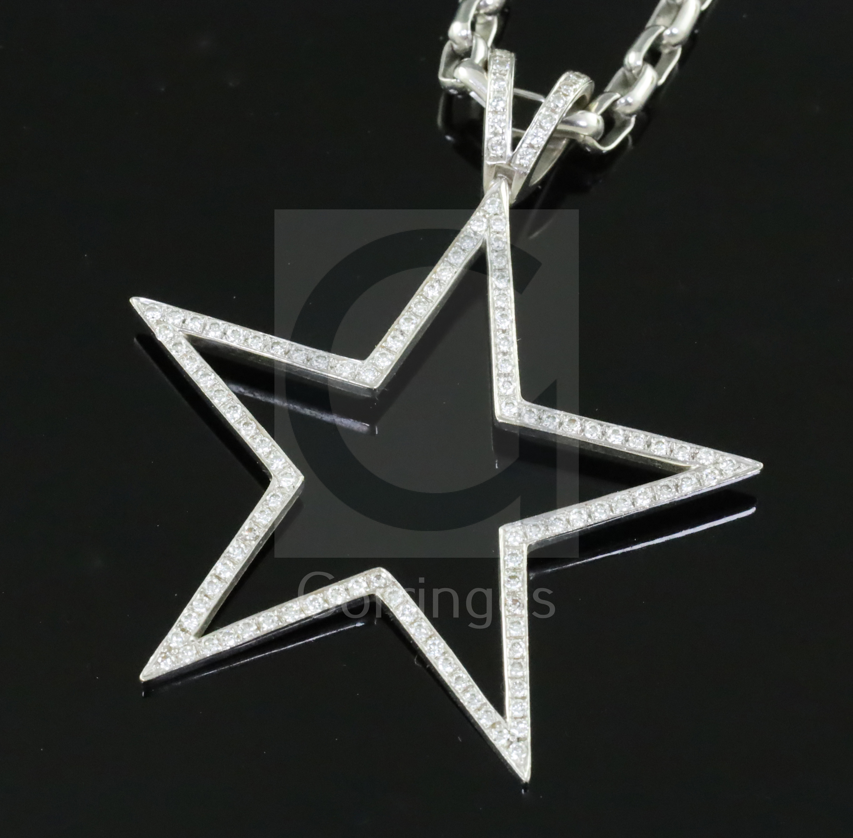 A modern Theo Fennell 18ct white gold and diamond set openwork star pendant, on an 18ct white gold