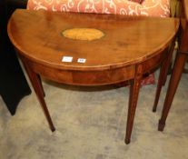 A George III mahogany and tulipwood banded 'D' shaped folding card table, with husk and paterae