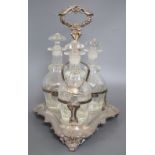 A plated three decanter tantalus of triangular form with leaf-wrapped handle, with bottles and