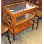 A satinwood three tier trolley, with tray top and glazed upper section, possibly Asprey, W.80cm