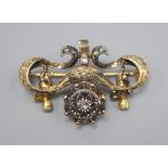 An ornate Victorian diamond set gold and silver suspension brooch, with central cluster flanked by