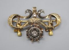 An ornate Victorian diamond set gold and silver suspension brooch, with central cluster flanked by