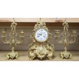 A Louis XV design cast ormolu rococo eight day mantel clock, with matching two branch candelabra, by
