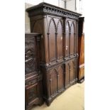 A 19th century French Gothic design stained pine press cupboard with two doors enclosing two shelves