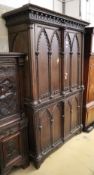 A 19th century French Gothic design stained pine press cupboard with two doors enclosing two shelves