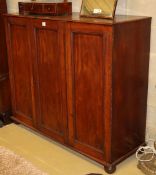 A Victorian panelled mahogany three door linen press, doors enclosing three sliding trays, W.