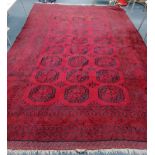 A large Afghan red ground carpet, 490 x 315cm
