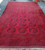 A large Afghan red ground carpet, 490 x 315cm