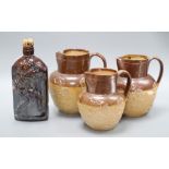 A set of three graduated Doulton stoneware jugs and a similar bottle, height 19cm