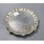 An Edwardian silver salver with fluted scallop shell pie-crust rim and pad feet, London 1909,