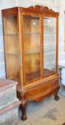 An Anglo Indian walnut two door china display cabinet, on short cabriole legs with claw and ball