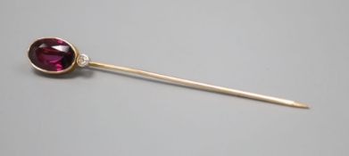 An Edwardian yellow metal, garnet and diamond set stick pin, 64mm, gross 2.2 grams.CONDITION: No