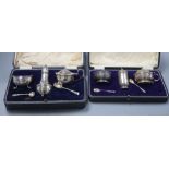 A George V three piece silver condiment set with pair of spoons and a similar three piece set with