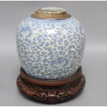 A 19th century Chinese blue and white jar and carved wood stand