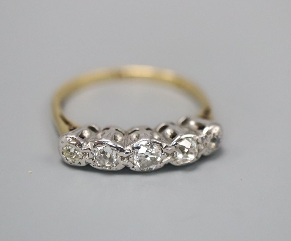 An 18ct and graduated illusion set five stone diamond half hoop ring, size L, gross 2.9 grams.