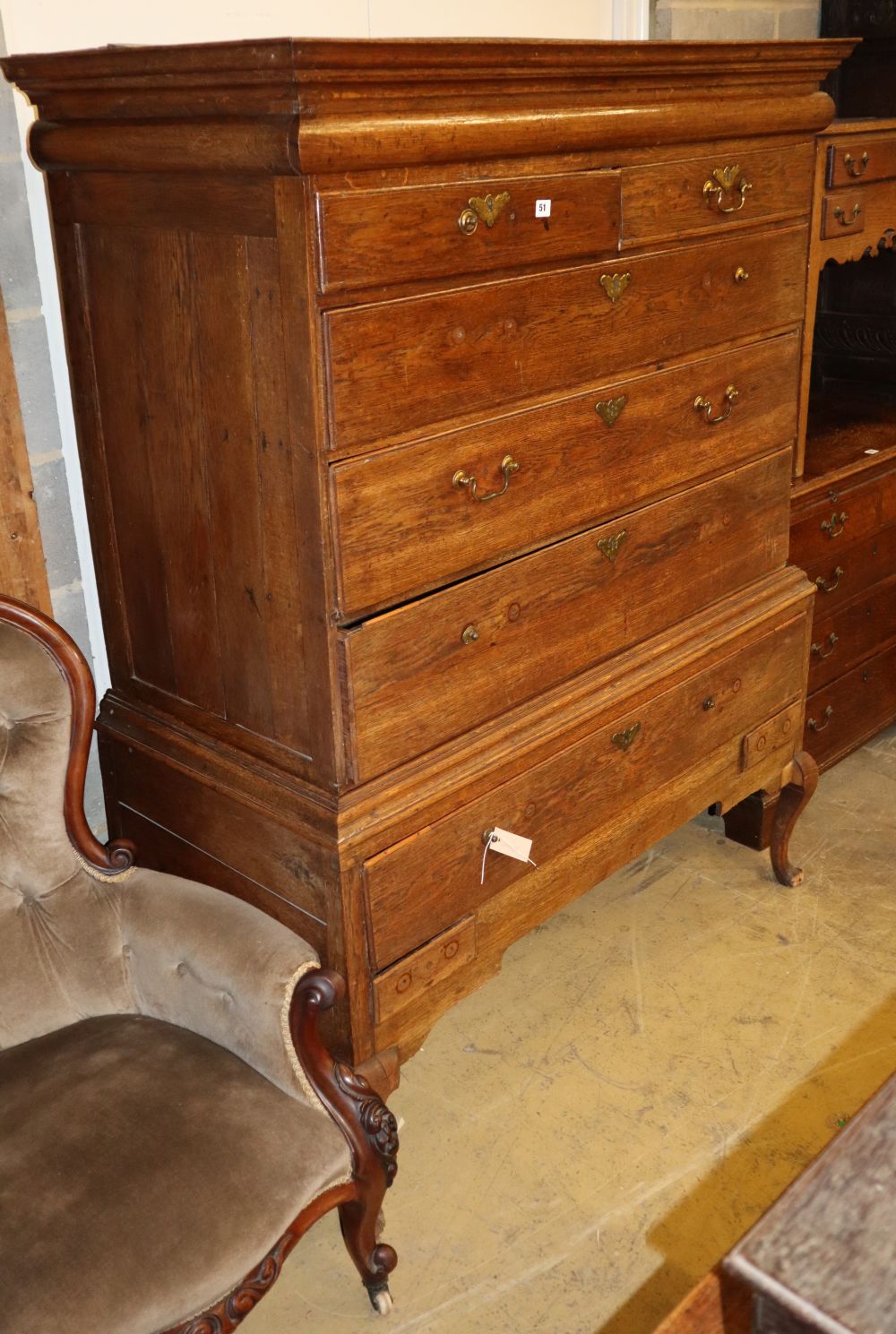 An early18th century oak chest on stand, with frieze drawer, two short and three graduated long