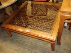 A Chinese pierced wood glass topped coffee table, W.106cm, D.112cm, H.42cm