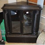 A Flemish ebonised oak two door glazed floor standing corner cupboard, W.87cm