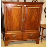 An early 19th century mahogany linen press, the top with a pair of fielded panelled doors over two