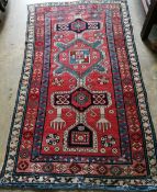 A Caucasian Kazak brick red ground rug, 178 x 102cm