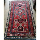 A Caucasian Kazak brick red ground rug, 178 x 102cm