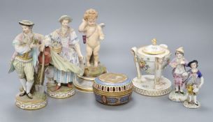 A pair of Meissen figures, a Meissen putti, two smaller Meissen figures, a lidded centrepiece and an